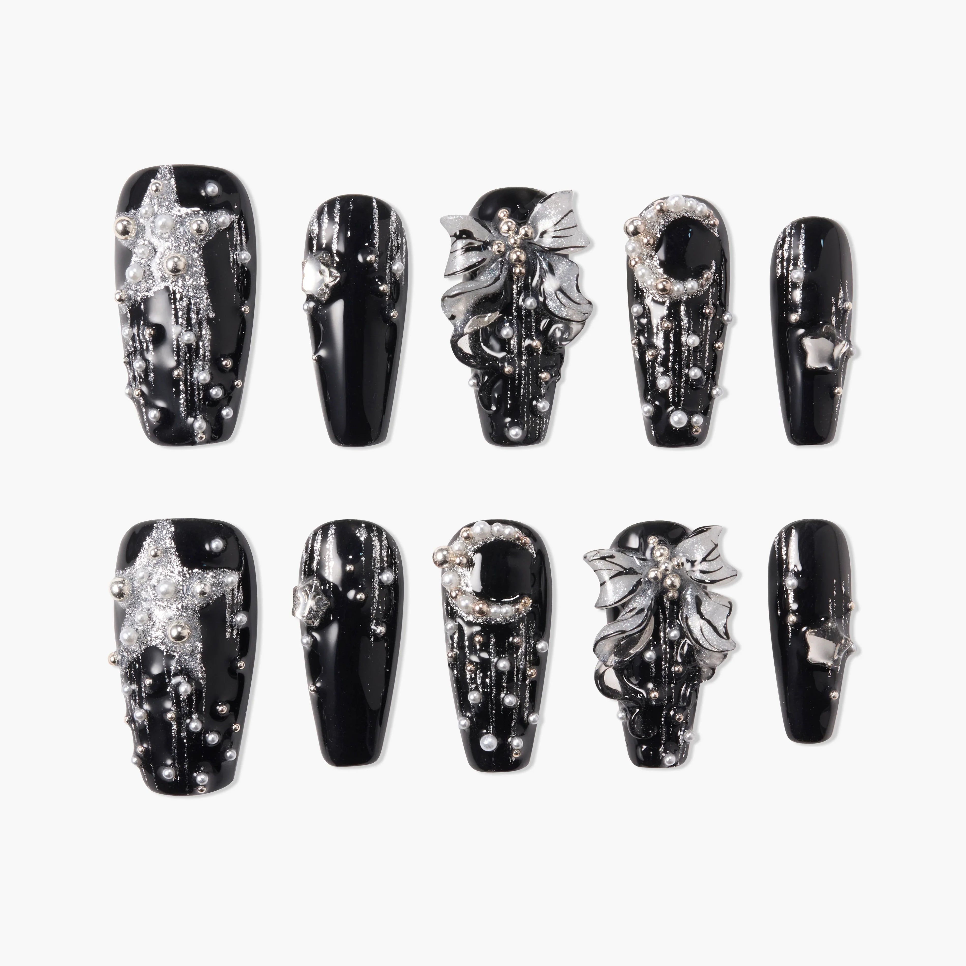 Black press-on nails with silver glitter stars, moons, bows, and 3D pearl accents