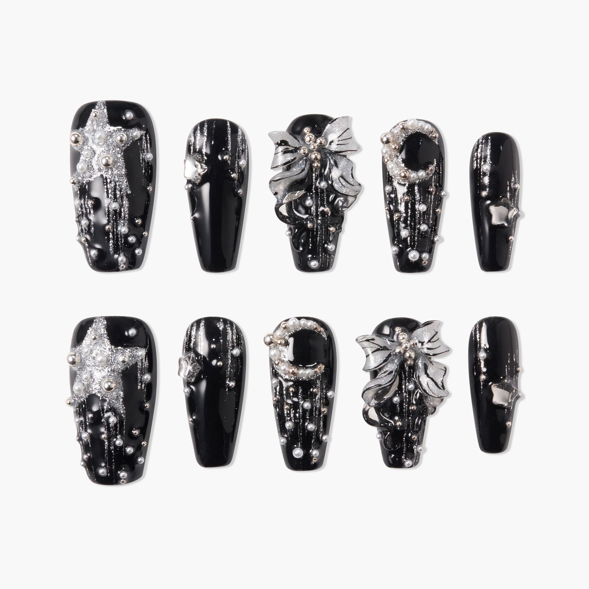 Black press-on nails with silver glitter stars, moons, bows, and 3D pearl accents