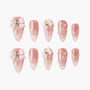 Pink ombre press-on nails with 3D bows, rhinestones, pearls, and elegant nail art