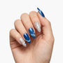 Hand with almond-shaped blue and silver press-on nails, featuring heart and polka dot designs.