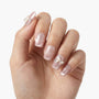 Hand with pink glitter press-on nails featuring rhinestones and 3D bow nail art