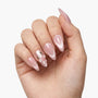 Hand with glossy pink press-on nails, accent nail features a white 3D flower design.