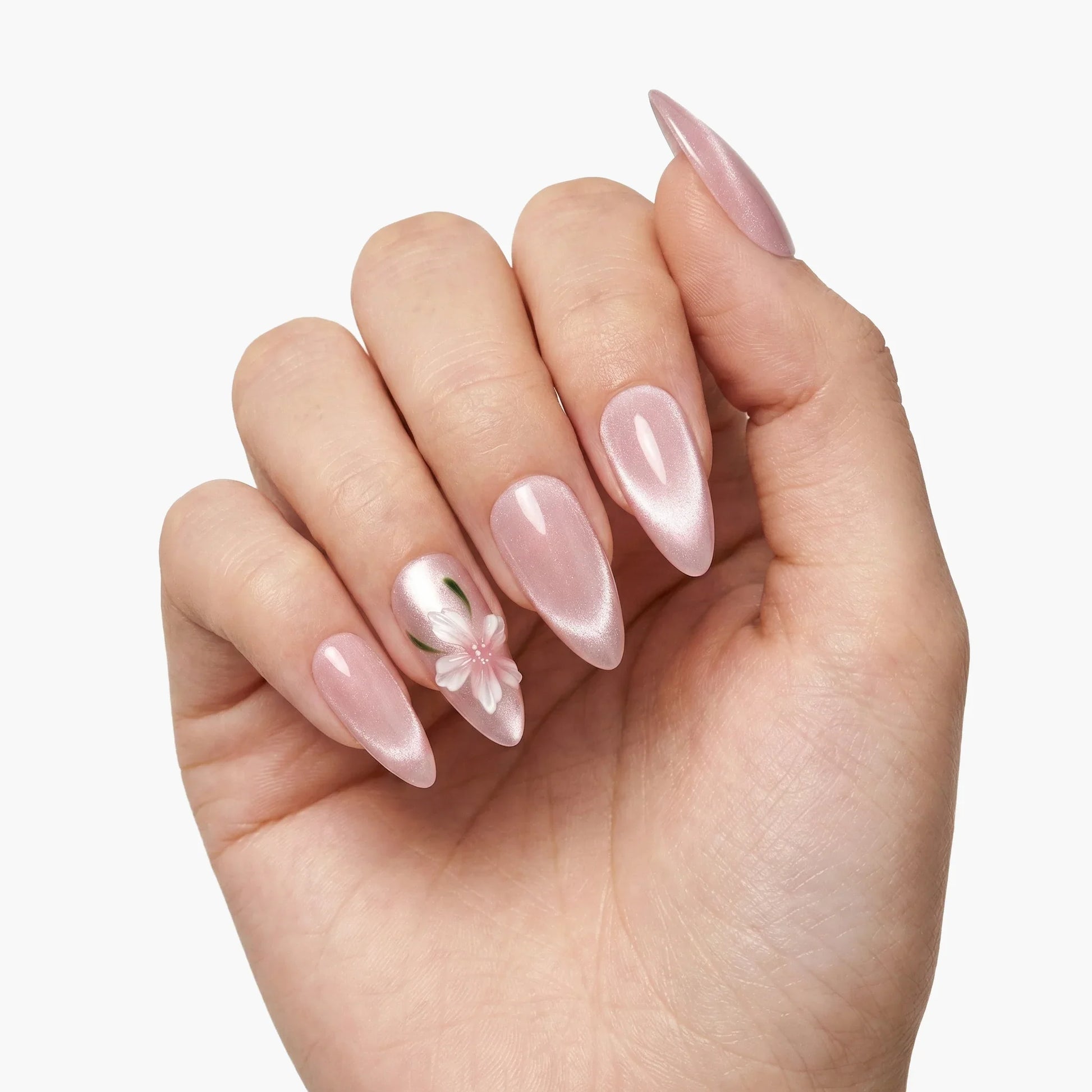 Hand with glossy pink press-on nails, accent nail features a white 3D flower design.