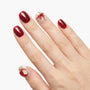 Hand with red glitter press-on nails, white accent nails with apple and bow designs