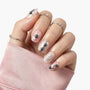 Hand with silver 3D press-on nails, metallic accents, and minimalist gemstone rings