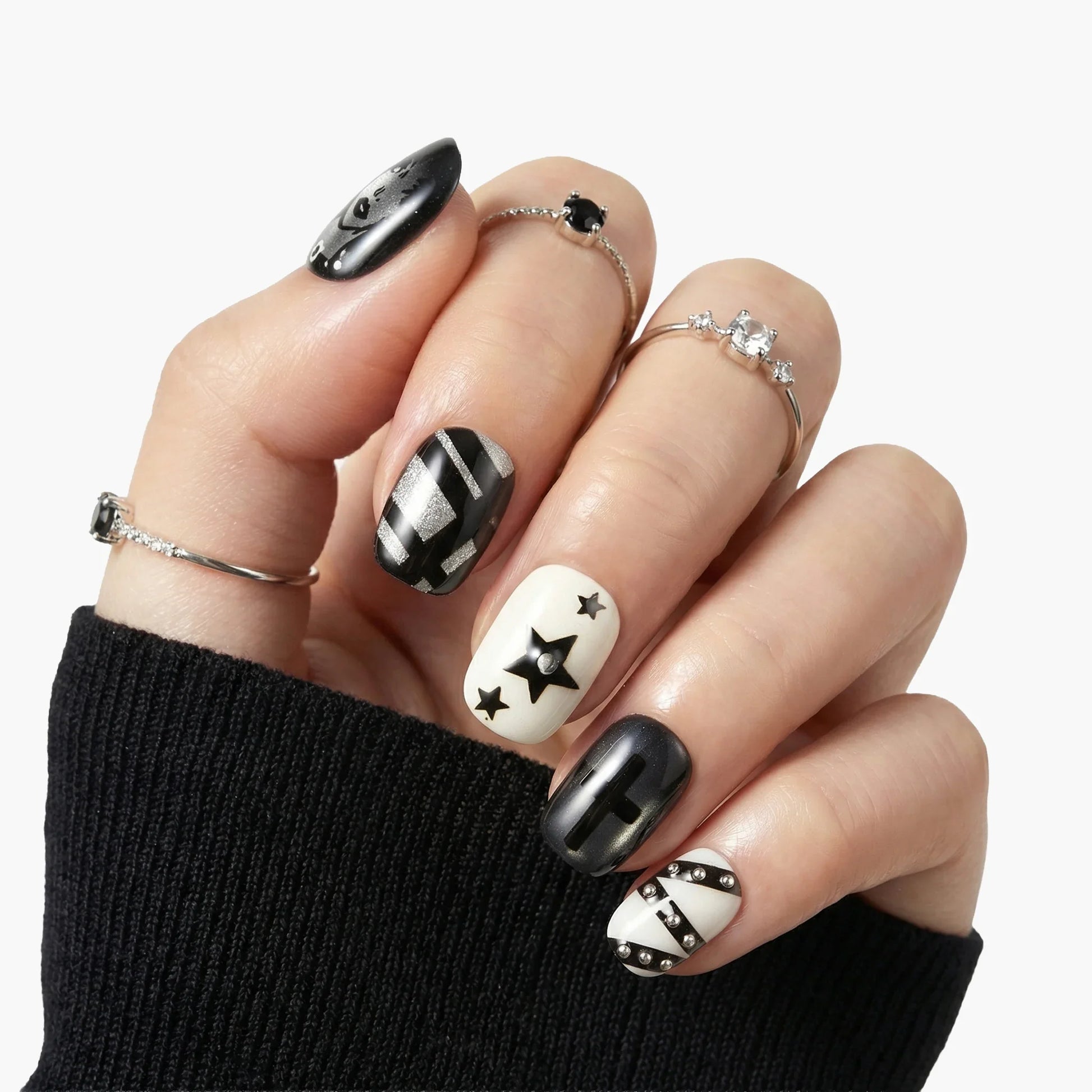 Hand with black and white geometric press-on nails featuring stars and stripes