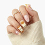 Hand with cute 3D bear press-on nails, pastel pink and brown designs, bow and star accents