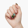 Hand with multicolored marble press-on nails and pink accent nail with gold studs