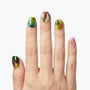 Hand with colorful marble press-on nails and pink accent nail with gold studs