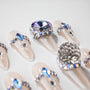 Handmade press-on nails with nude base and blue crystal rhinestone accents