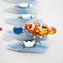 Blue press-on nails with large orange, blue, and clear gemstone accents and glitter details