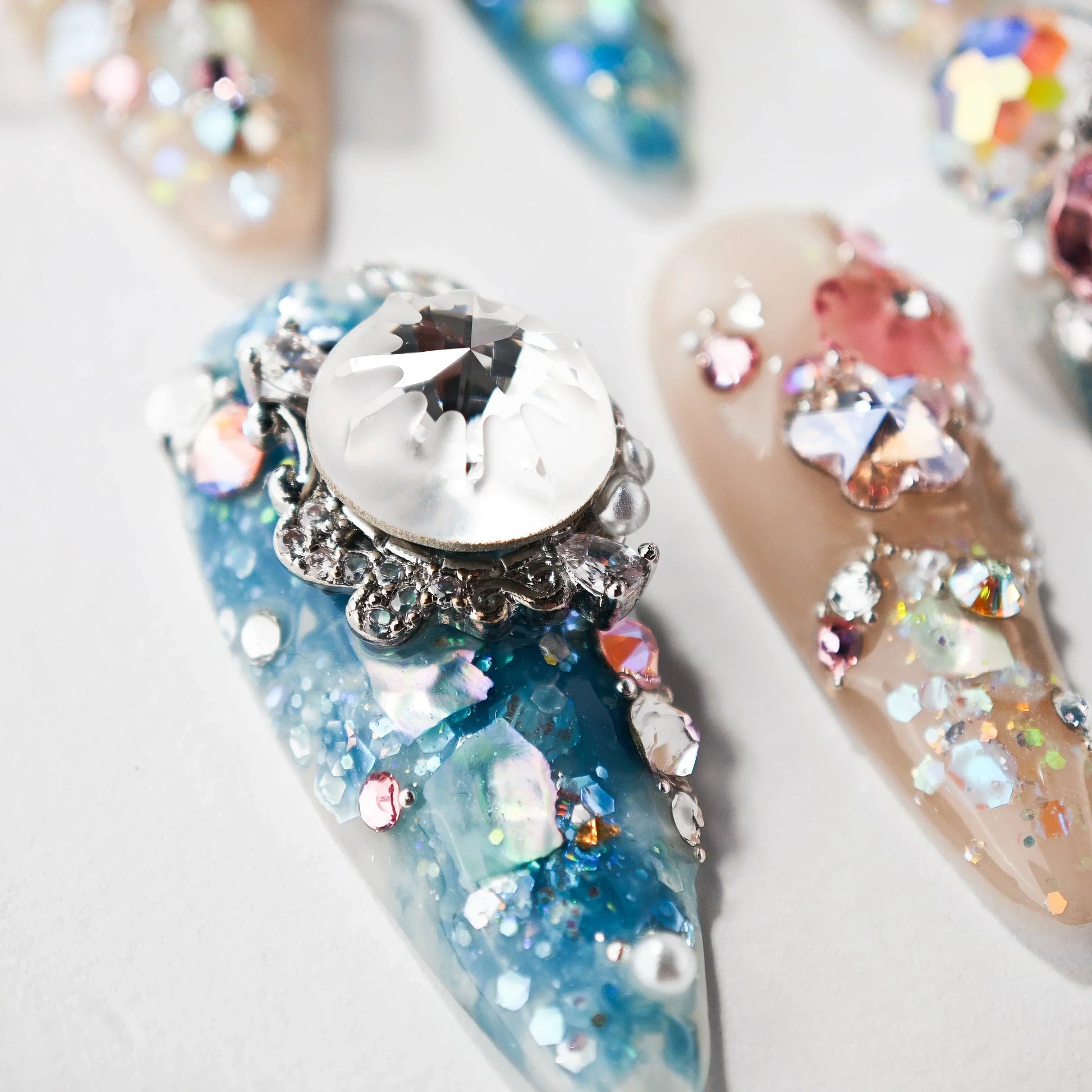 Handmade press-on nails with blue, pink, and crystal 3D rhinestone decorations