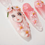 Handmade press-on nails with 3D floral art and anime-inspired face design in pink tones