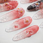 Handmade pink ombre press-on nails with 3D floral designs and gold bead accents