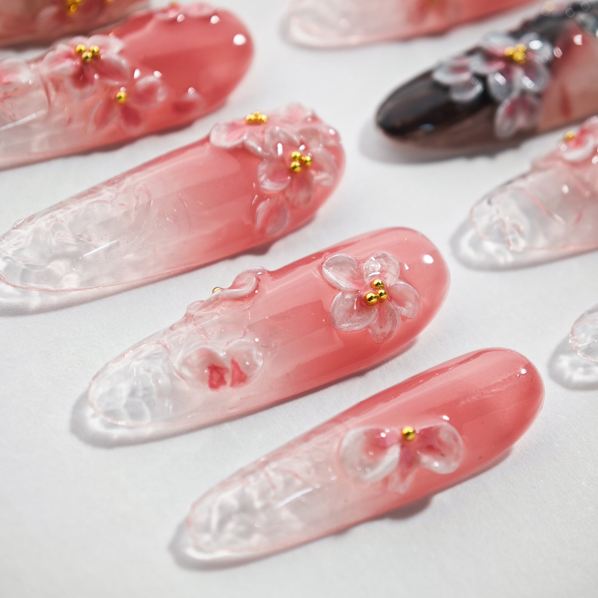 Handmade pink ombre press-on nails with 3D floral designs and gold bead accents