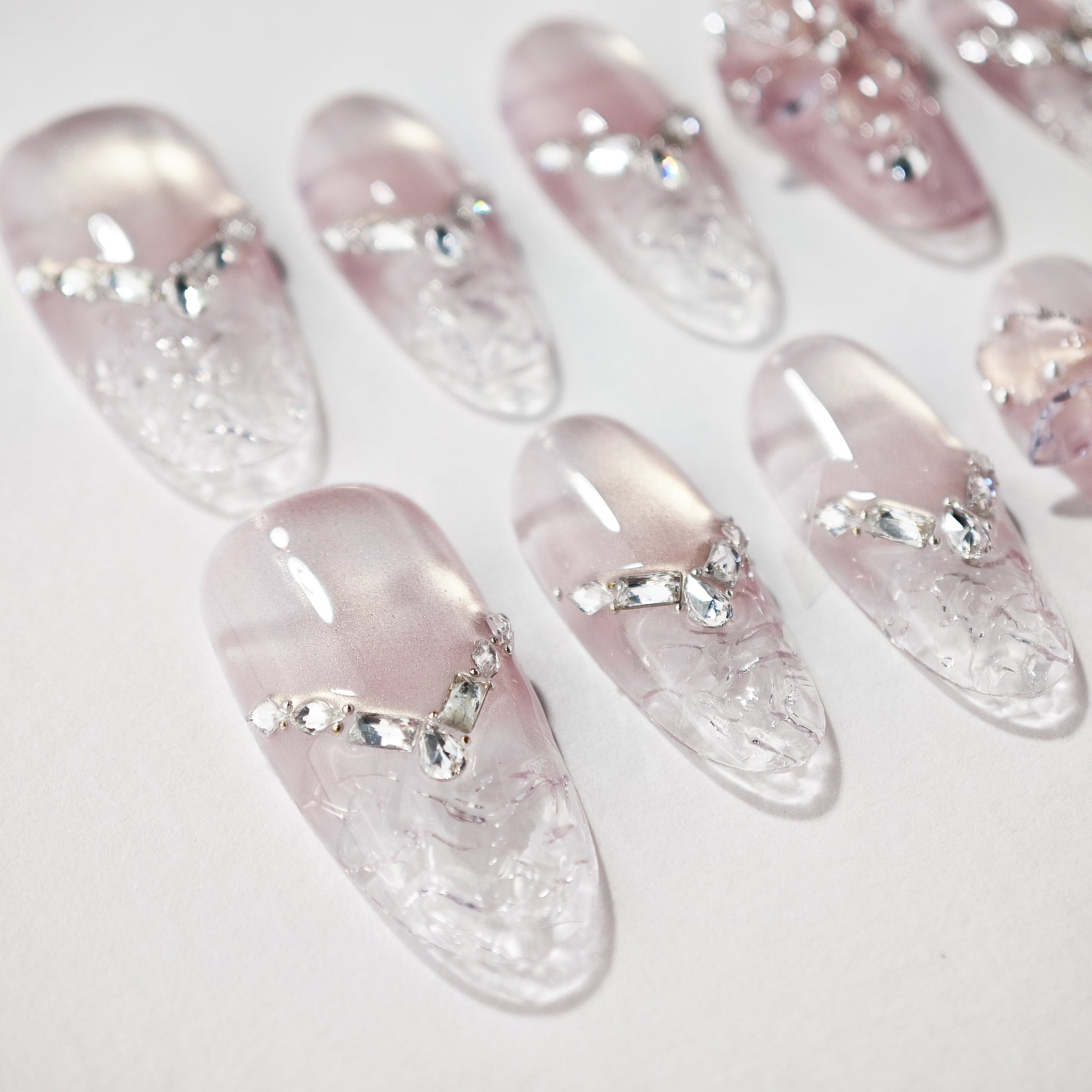 Handmade press-on nails with clear pink ombré design and crystal rhinestone accents