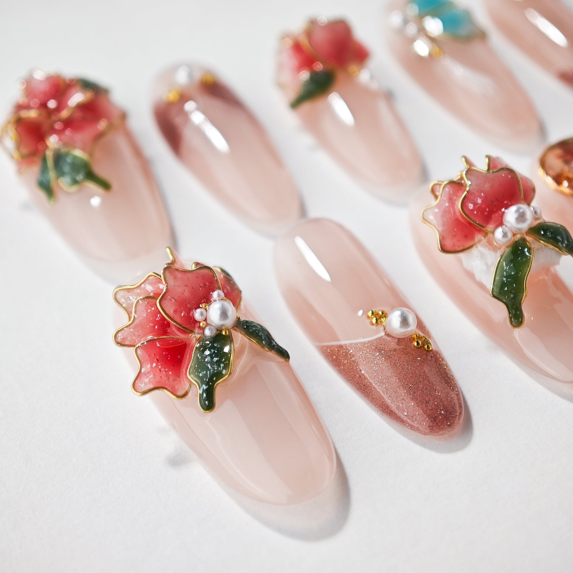 Handmade press-on nails with blush pink base, 3D floral accents, pearls, and gold details