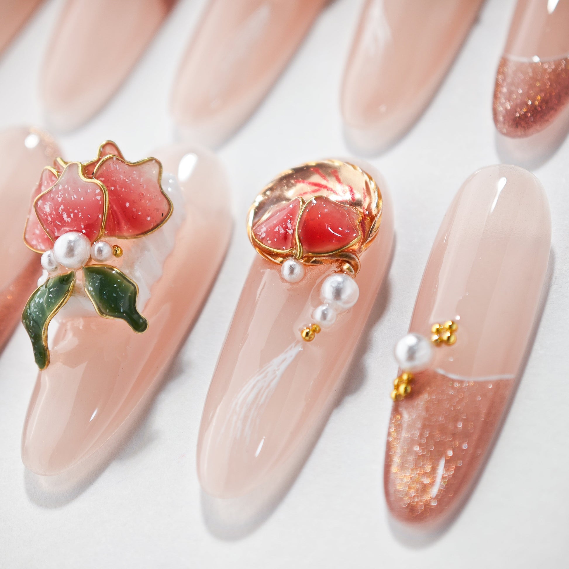 Handmade press-on nails with 3D floral and pearl designs on nude pink base