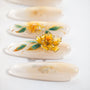 Handmade press-on nails with 3D yellow flower and green leaf design on a soft nude base