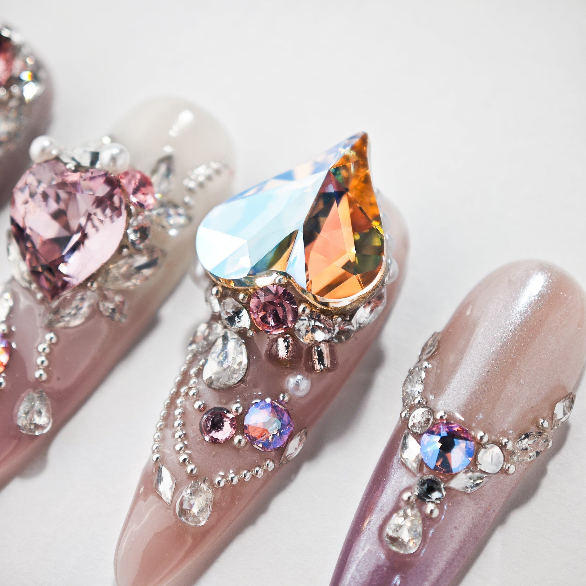 Handmade press-on nails with 3D heart crystals, rhinestones, and pink glitter designs