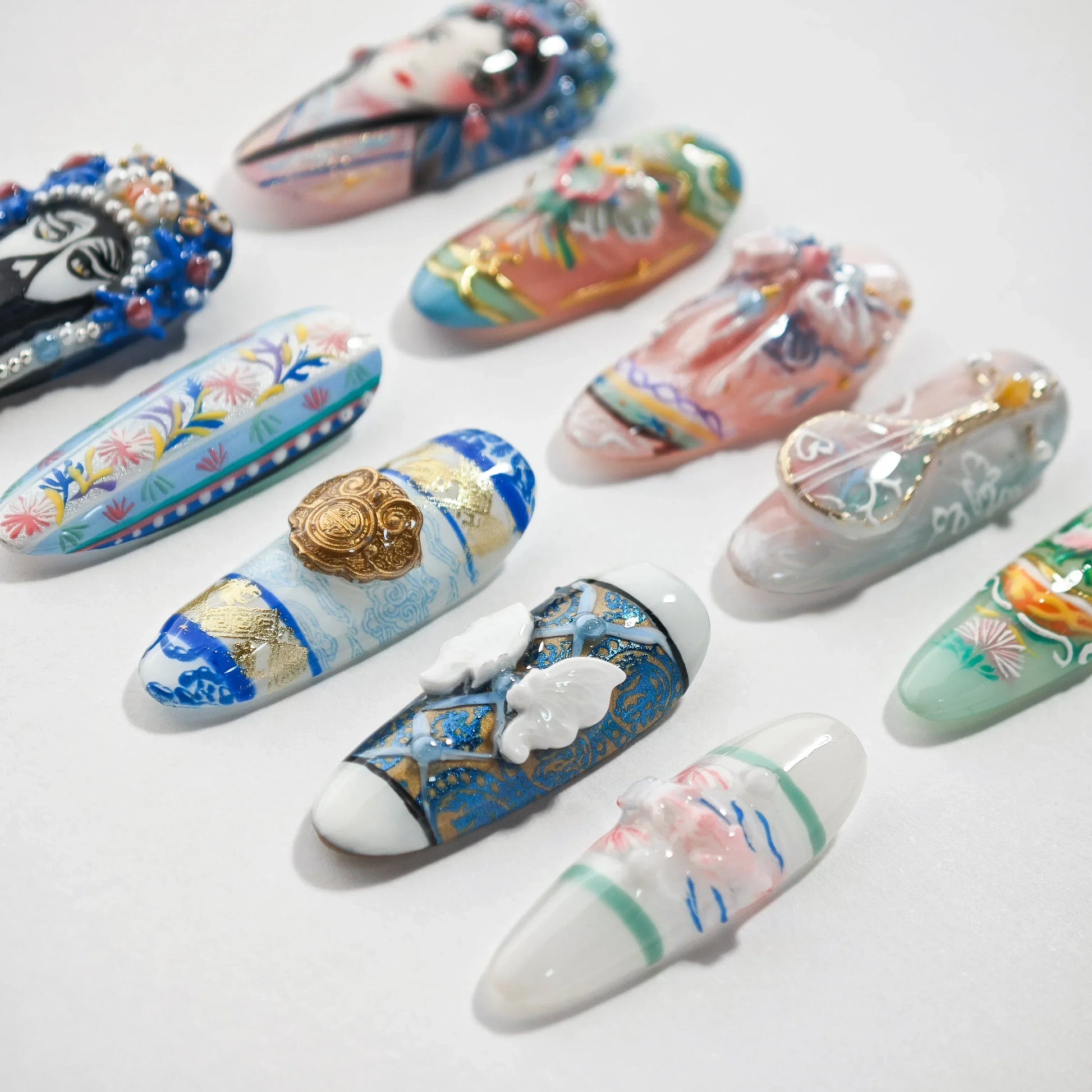 Handmade press-on nails with intricate 3D art, floral patterns, and ornate designs on white background.
