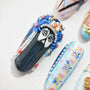Hand-painted press-on nail with ornate face design and 3D beaded blue headdress