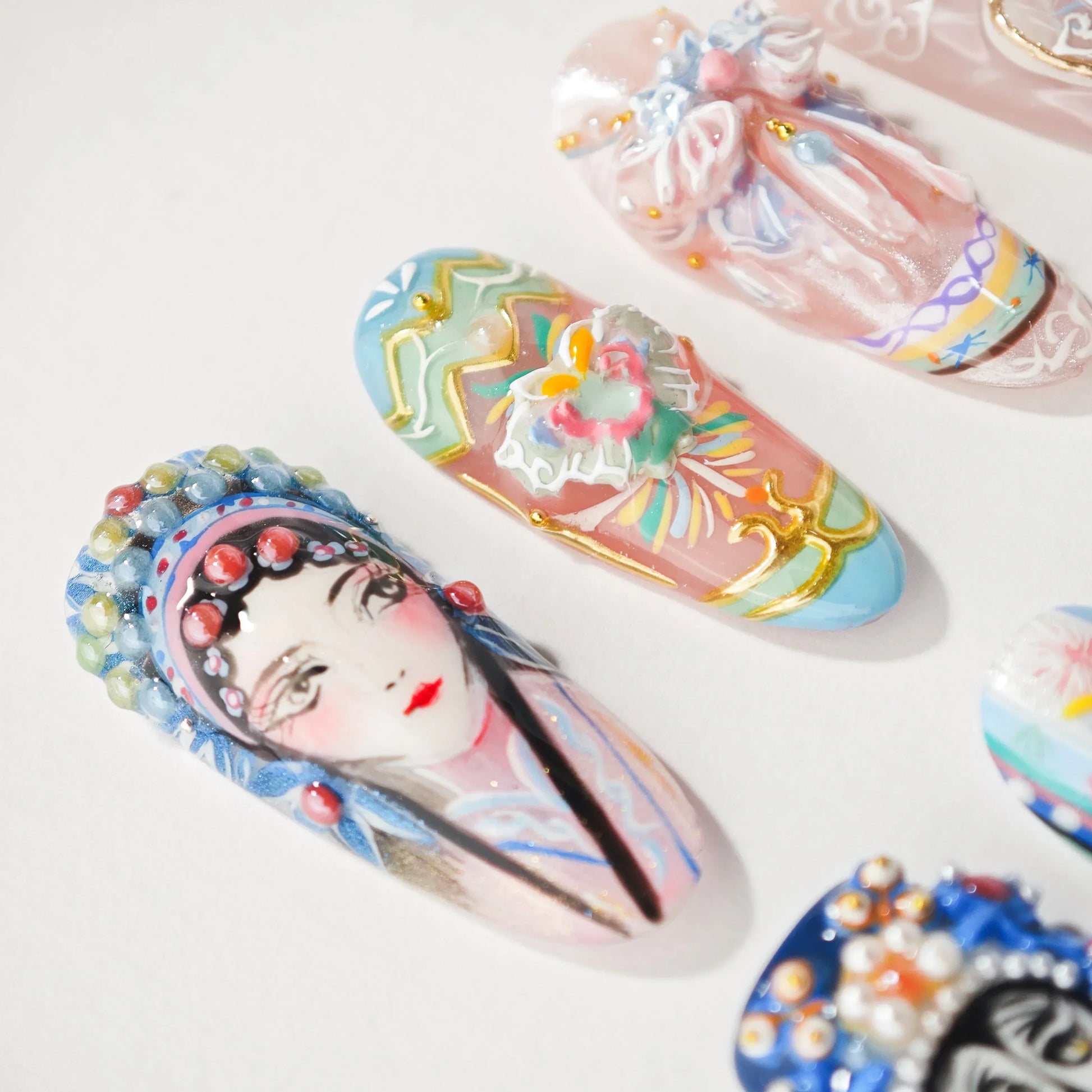 Handmade press-on nails with colorful floral designs and traditional painted face art