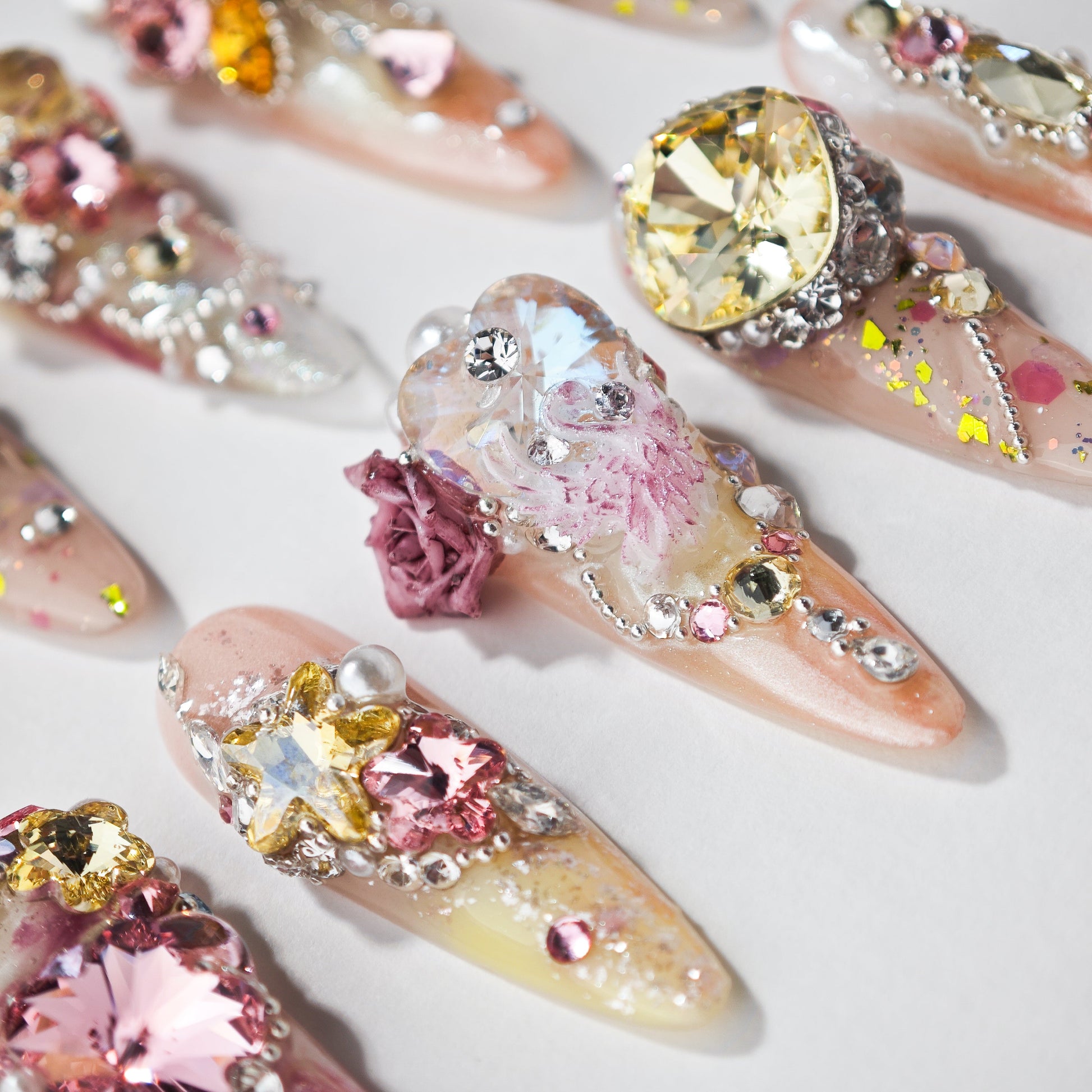 Handmade press-on nails with 3D floral designs, rhinestones, and colorful crystals.