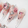 Handmade press-on nails with pink gemstones, 3D rose, pearls, and sparkling glitter accents