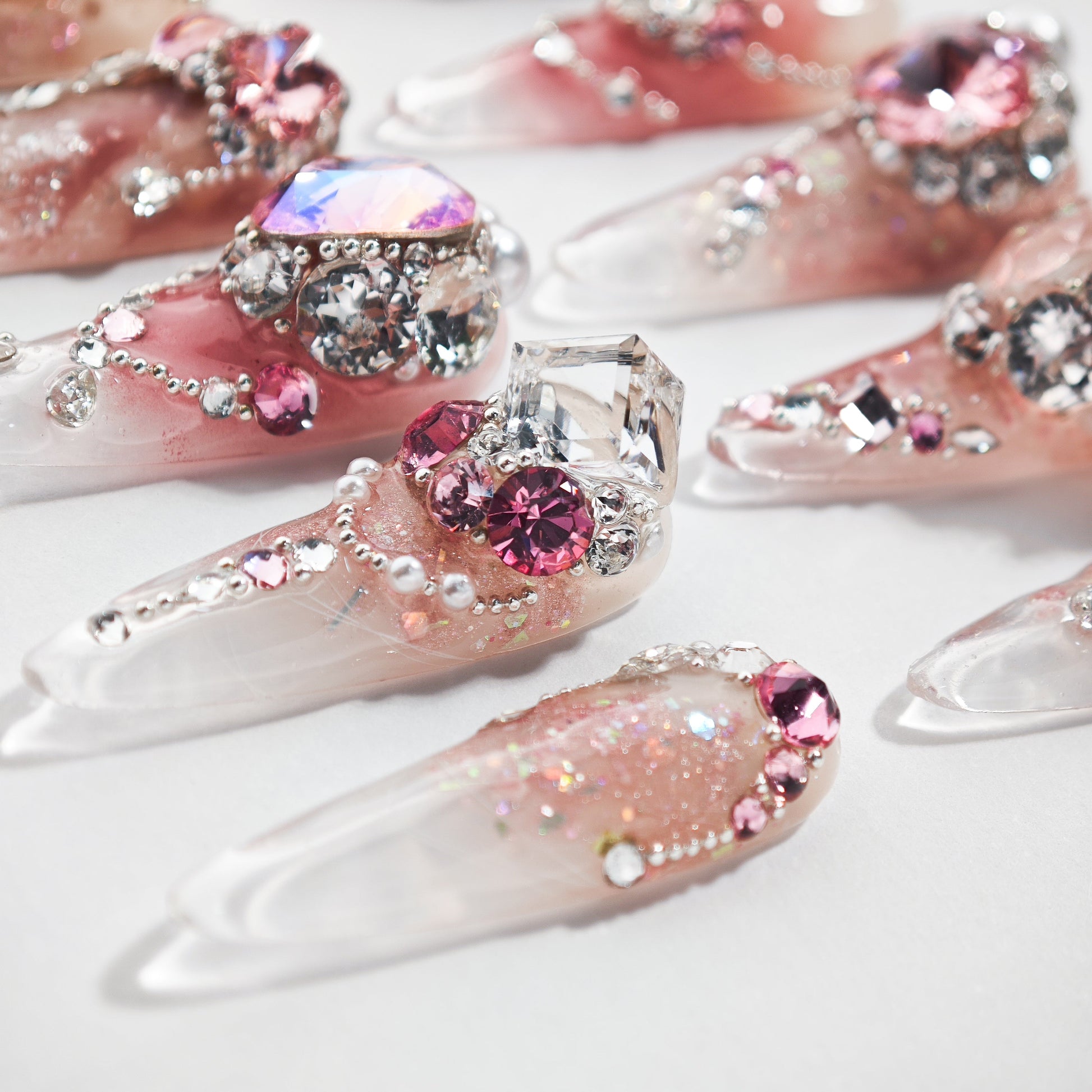 Long handmade press-on nails with pink glitter and 3D gemstone rhinestone accents